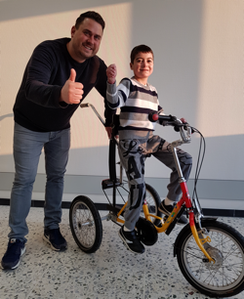 Sven Keller von Kidz & Co freut sich mit Varoj über das neue Dreirad