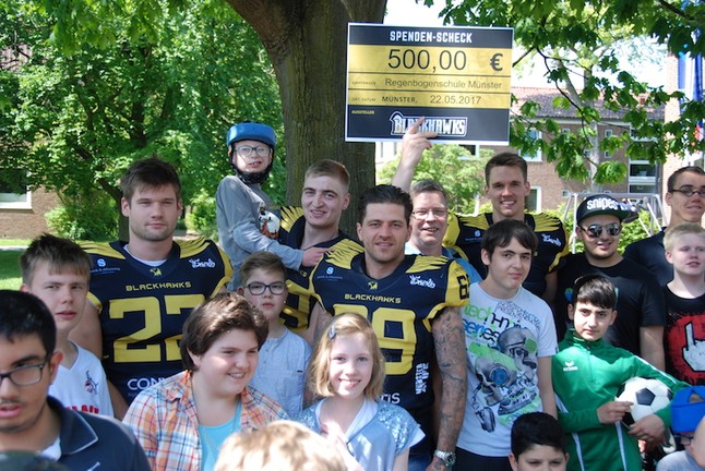 Schüler und Blackhawks freuen sich zusammen über die Spende
