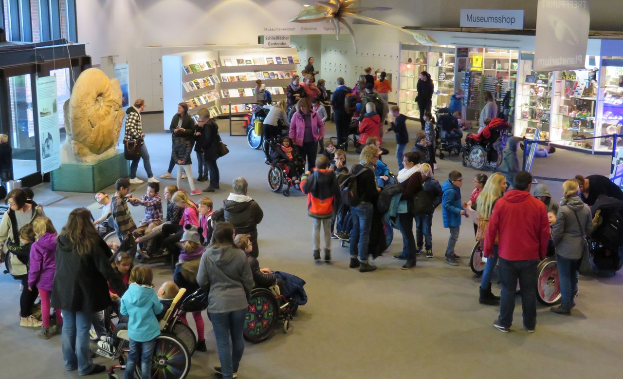 Die Grundstufenschüler*innen und Lehrkräfte warten im Foyer des Planetariums auf die große Vorstellung