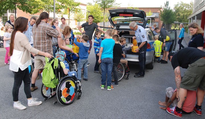 Ein Polizist zeigt den Kindern das Polizeiauto