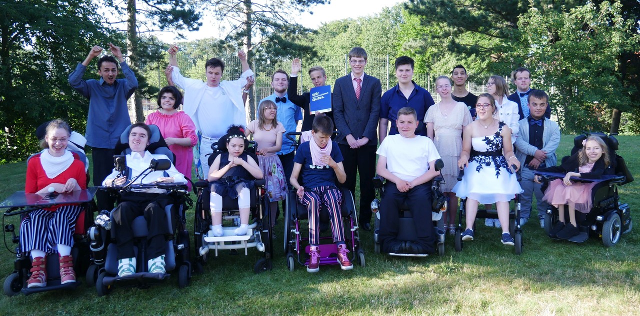 Die Schülerinnen und Schüler des Entlassjahrgangs 2019 stehen zusammen auf einer Wiese für ein Gruppenbild.